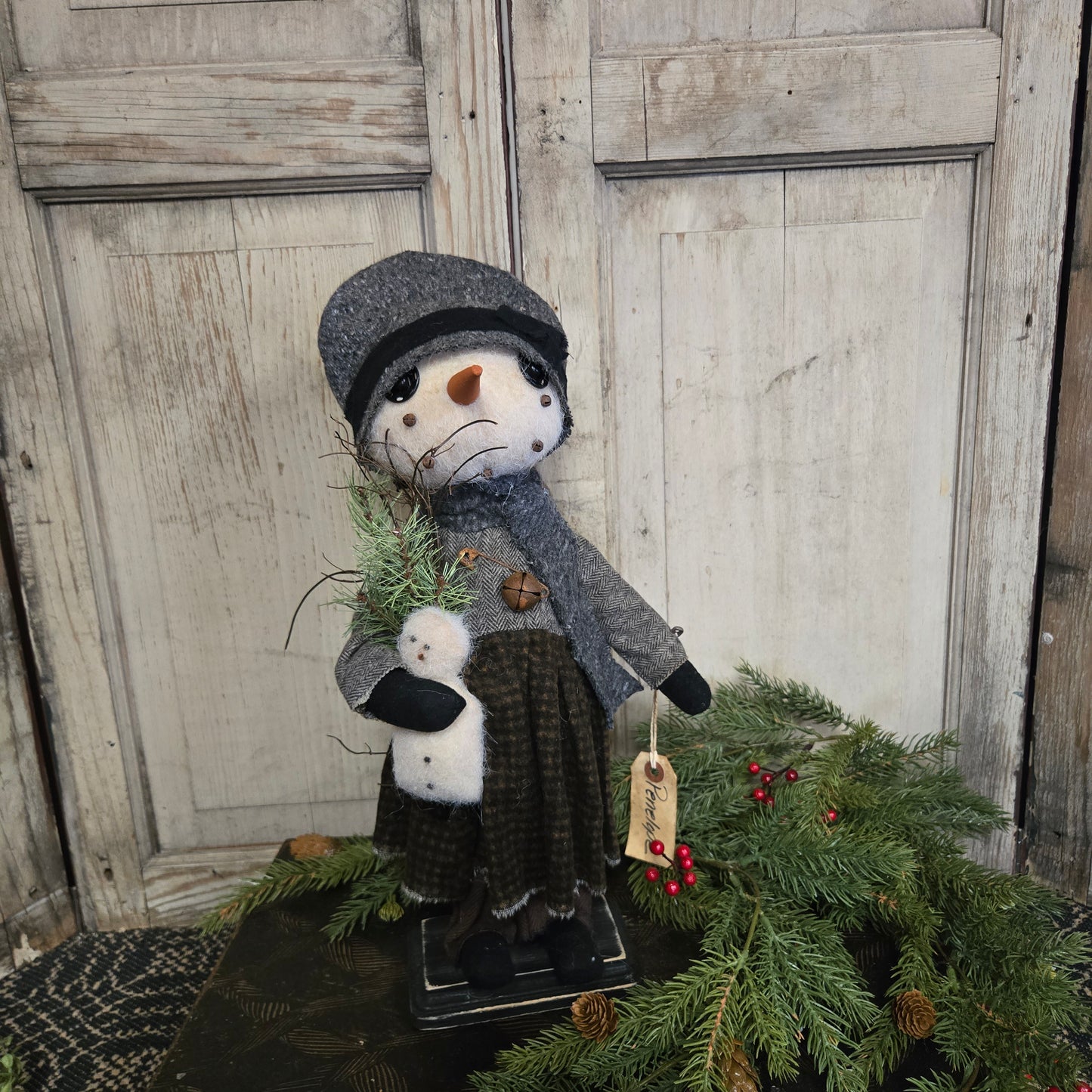 Decorative snowman figure with a tag on a wooden door