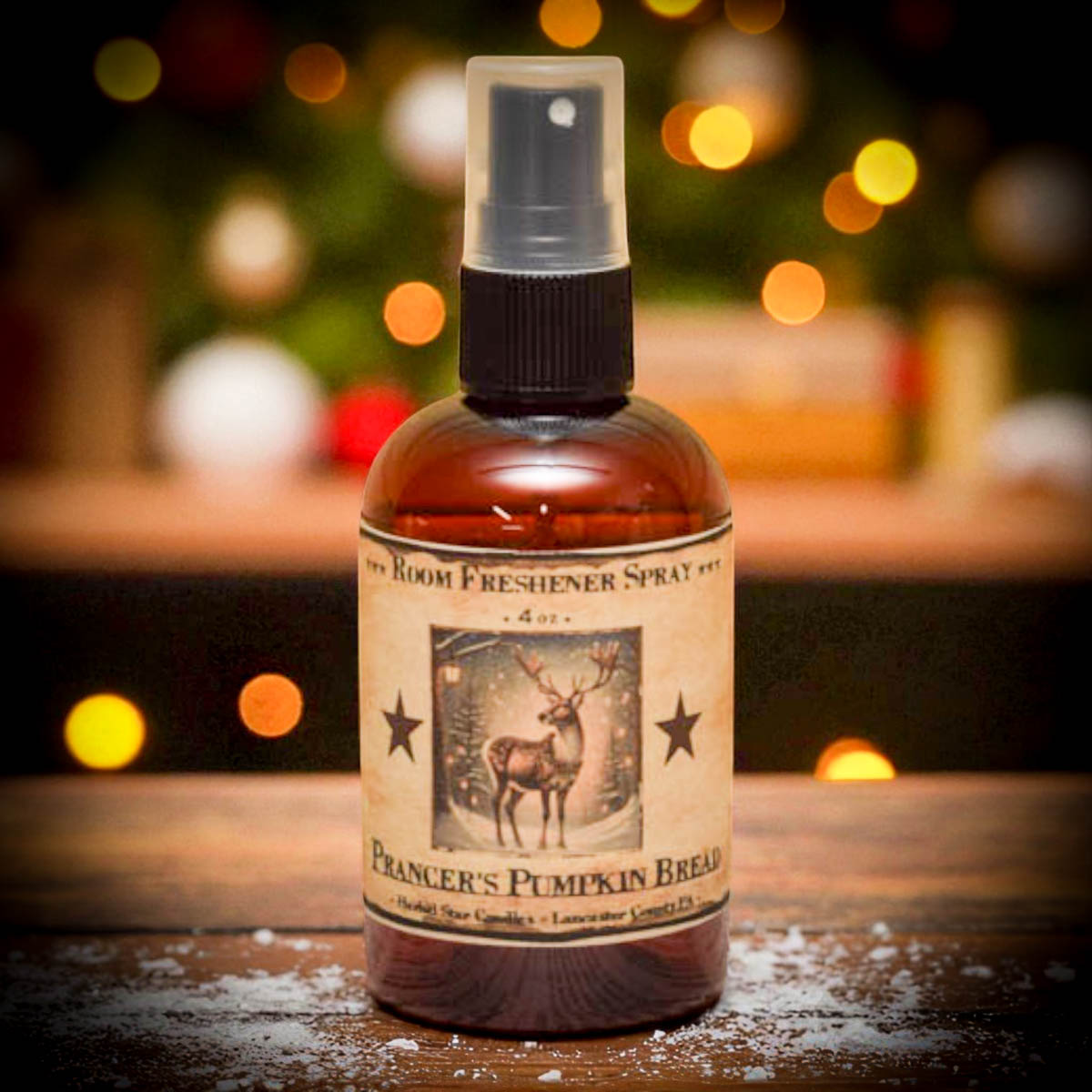 Room freshener spray bottle with a label featuring a deer and text on a wooden surface with blurred lights in the background.