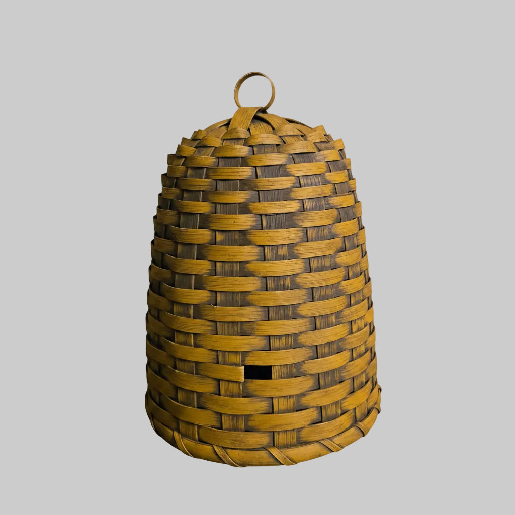 Woven yellow and brown beehive-shaped container on a gray background