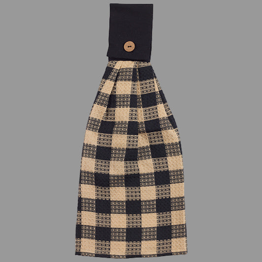 A black and beige checkered hand towel with a tab on the top for hanging.