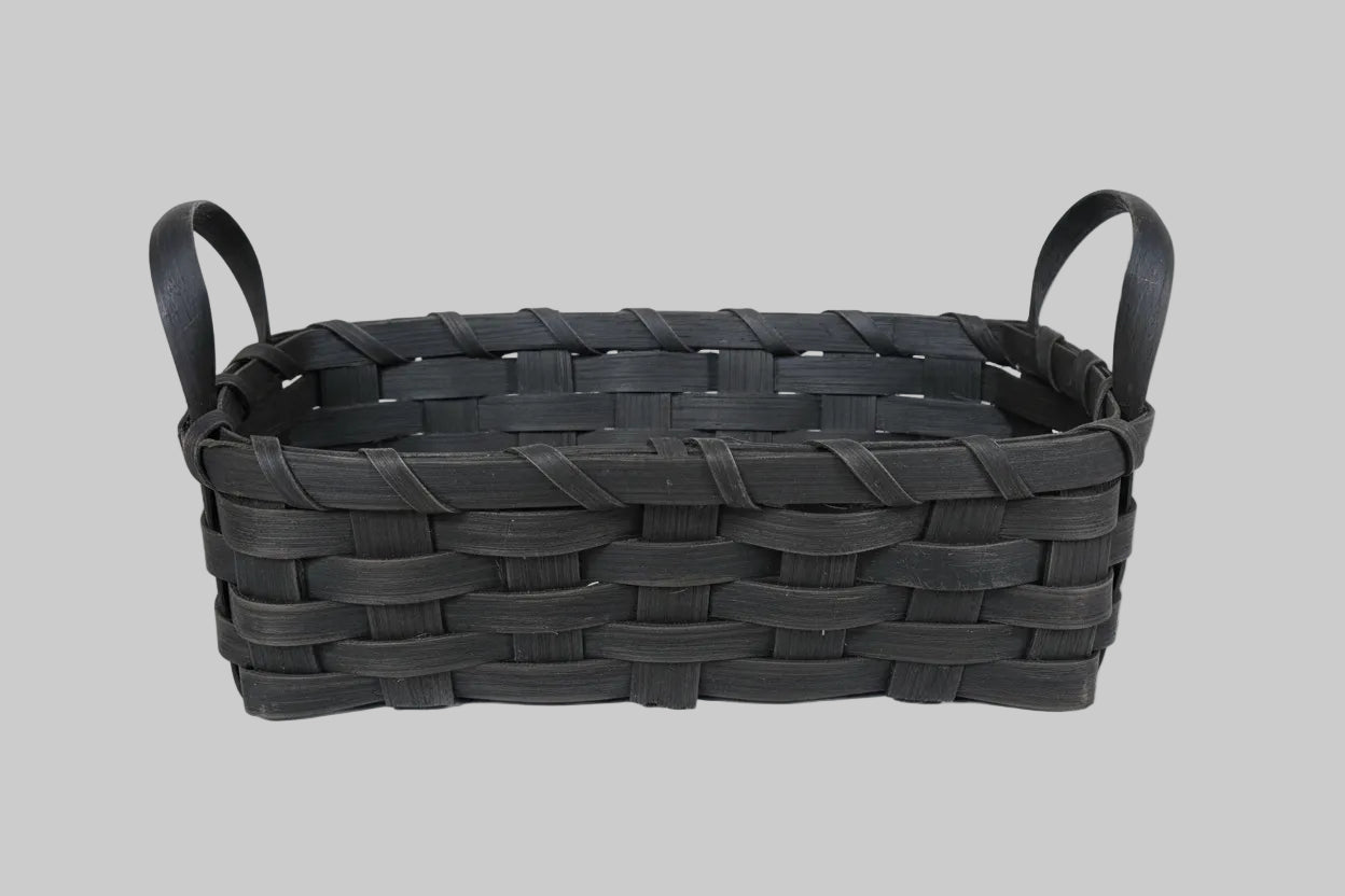 Woven black basket on a wooden surface