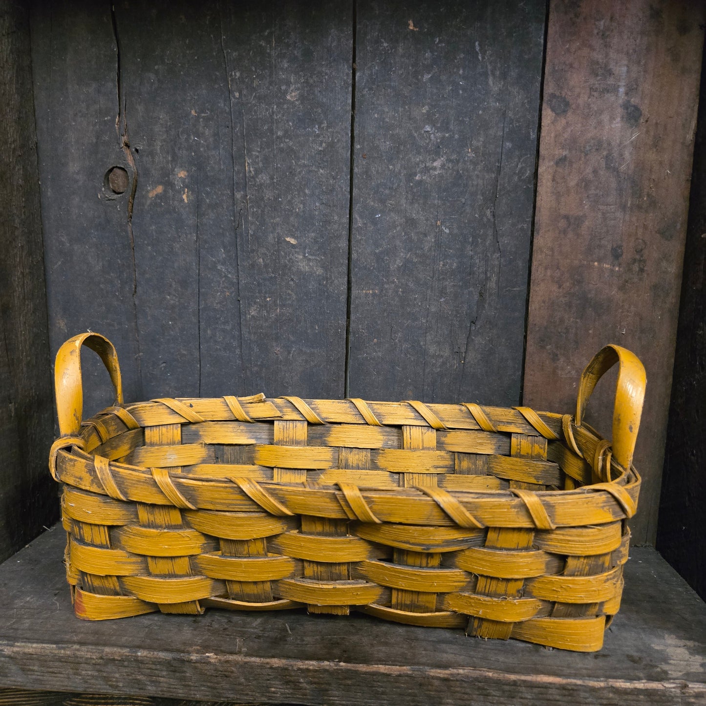 Woven mustard basket on a dark wooden background