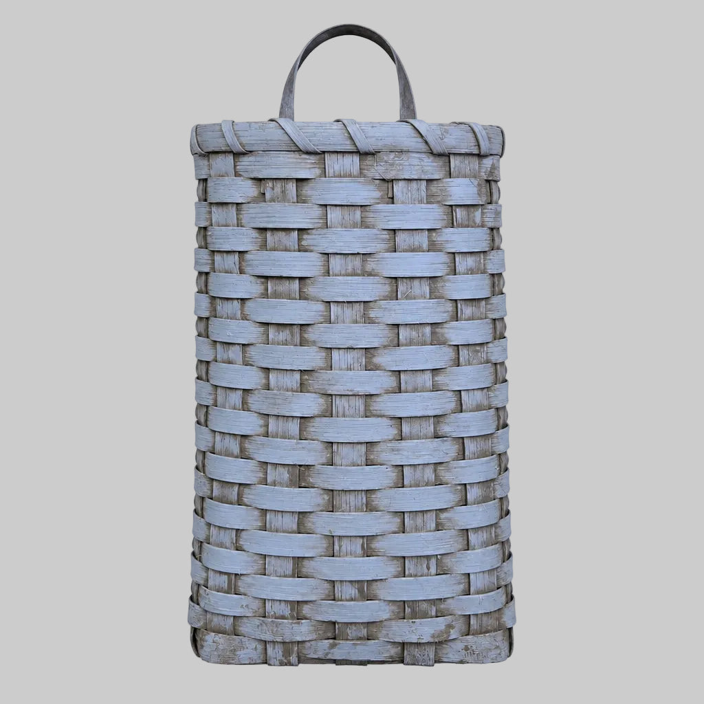 A handwoven door basket in a robins egg blue color, displayed against a grey background.