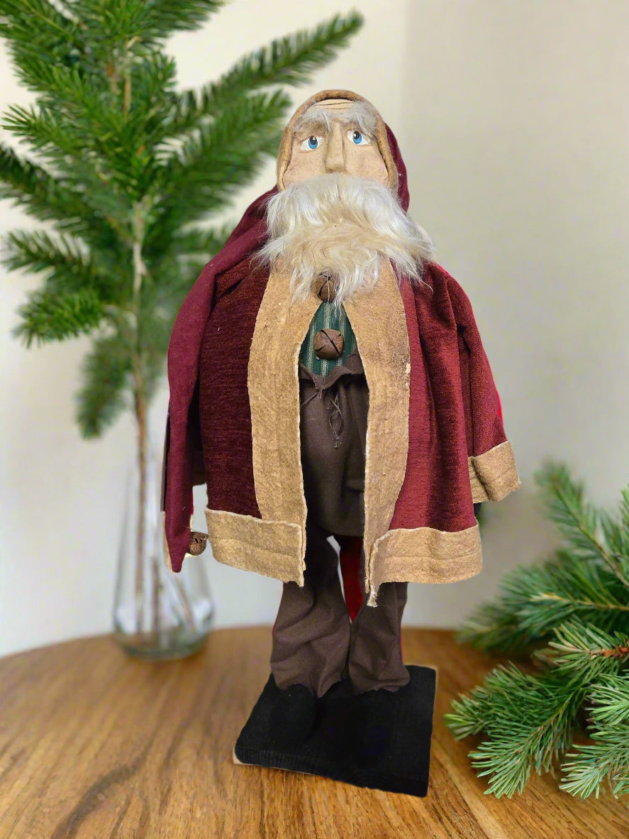 Primitive fat Santa wearing red coat with brown pants