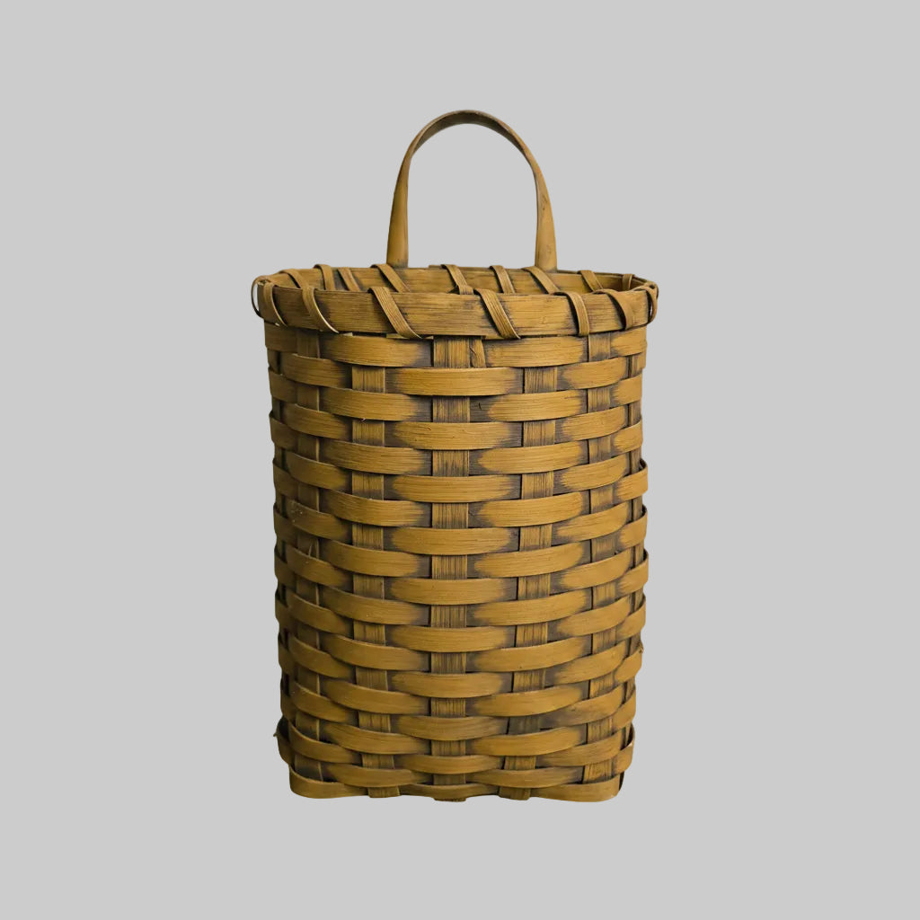 Woven basket with a handle on a gray background
