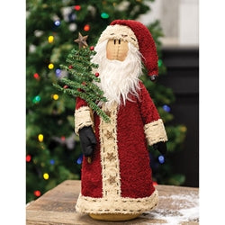A fabric doll depicting a primitive style Santa Claus with a long coat, standing 16 inches high, holding a decorated pine tree and adorned with star and jingle bell accents.