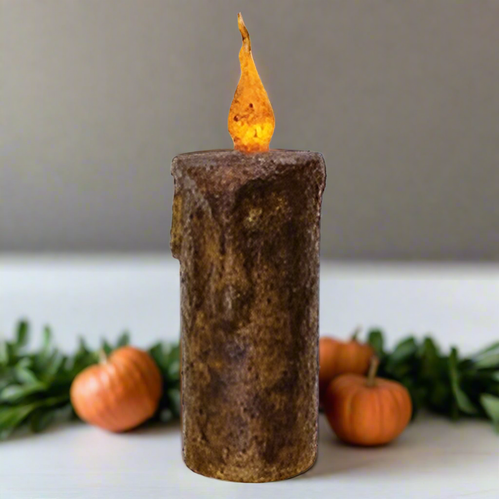 Decorative candle with a flame on a white background with pumpkins around it