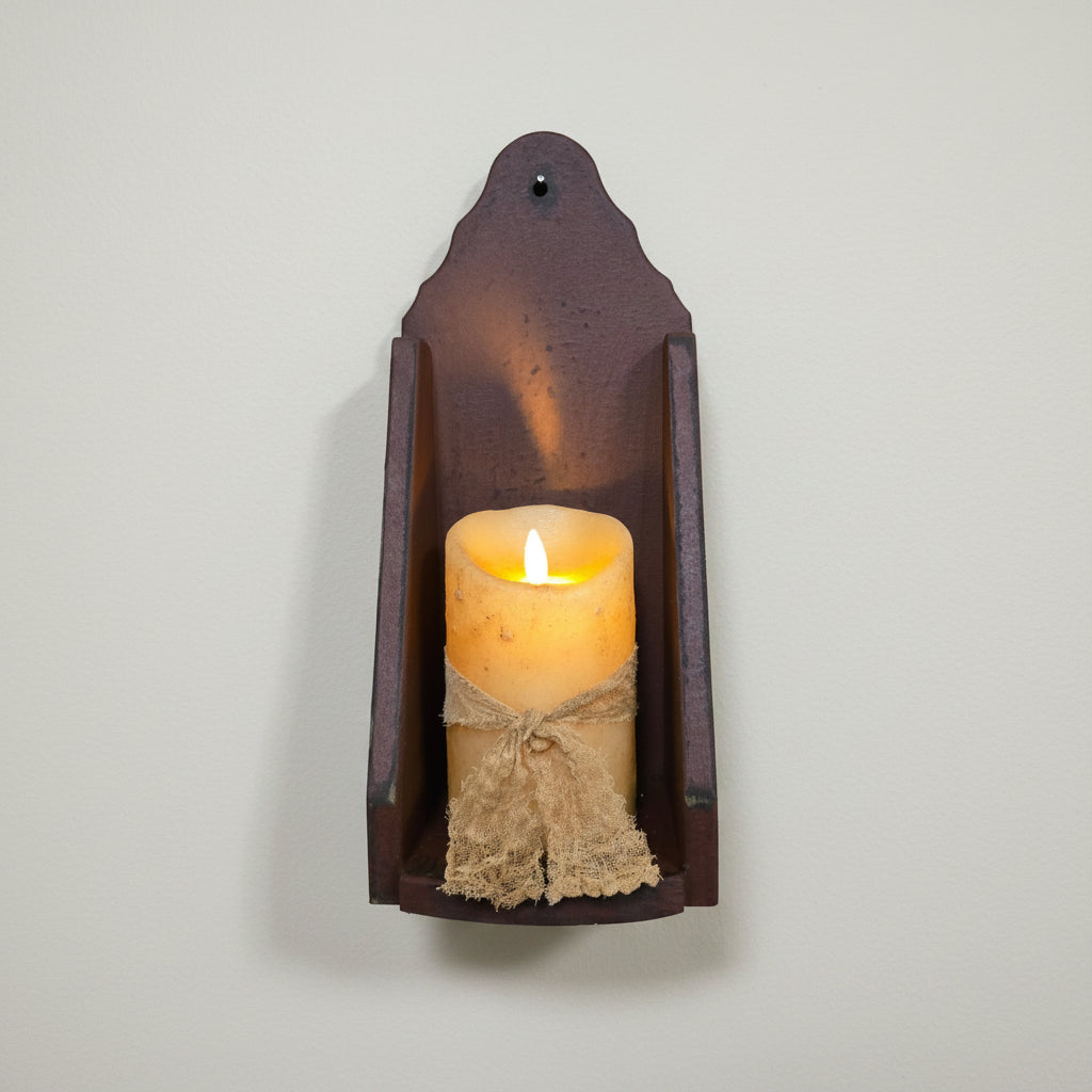 Decorative wall sconce with a lit candle on a rustic wooden background