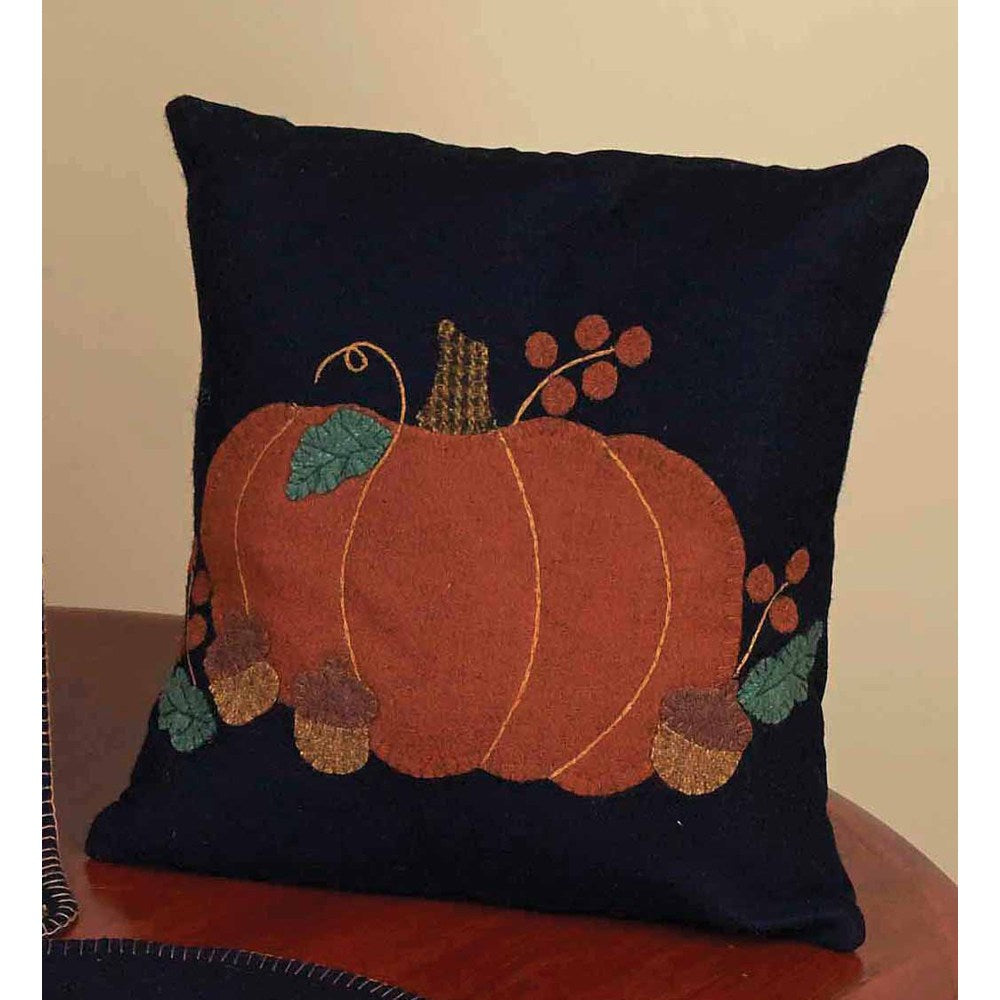 A square-shaped throw pillow with a decorative design featuring pumpkins, acorns, and autumn-themed leaves on a dark blue background.