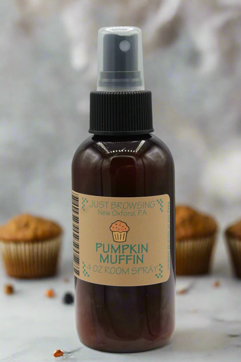 A 4oz bottle of Pumpkin Muffin room spray with a mist spray top. The label features the product name and an image of a cupcake.