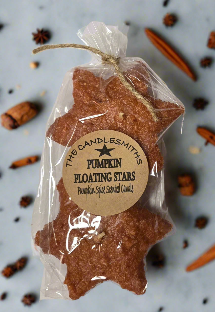 Two star-shaped floating candles with a pumpkin scent, packaged in clear wrapping with a label.