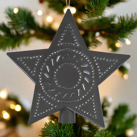 A smokey black tin star tree topper with punched designs and a solid metal structure.