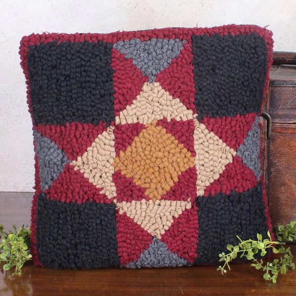 Decorative pillow with a geometric pattern on a wooden surface.