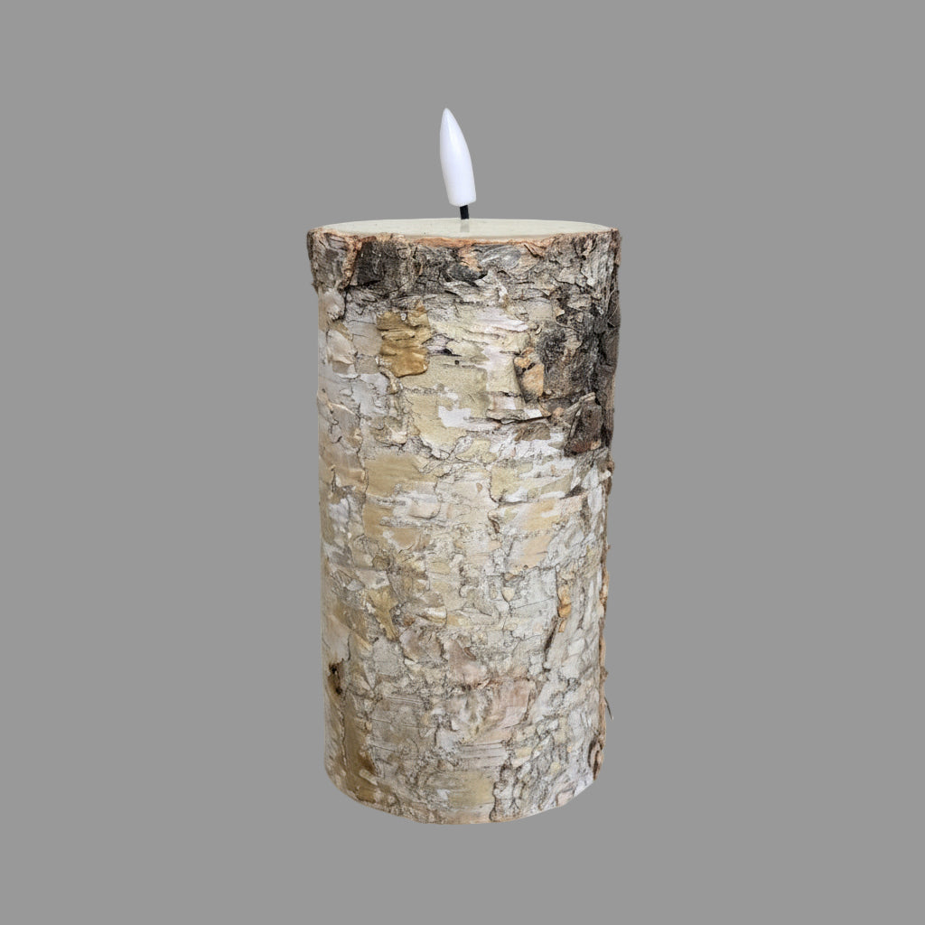 Candle made from a birch log on a textured surface