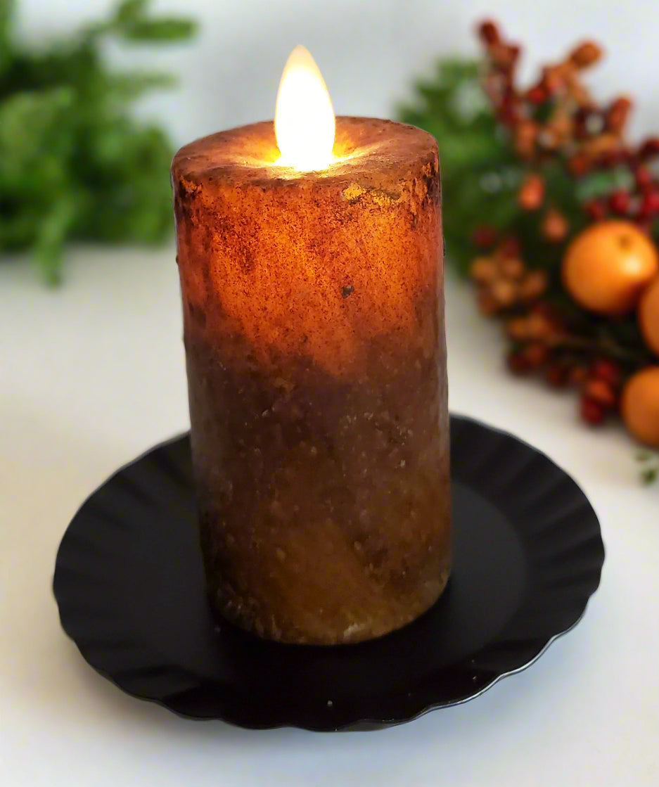 Realistic moving flame mini pillar candle with a brown wax, flickering flame on top, placed on a black round holder.