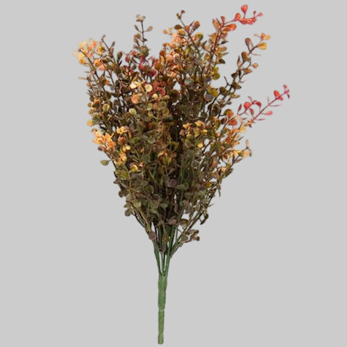 Artificial plant branch with orange and green leaves on a white background