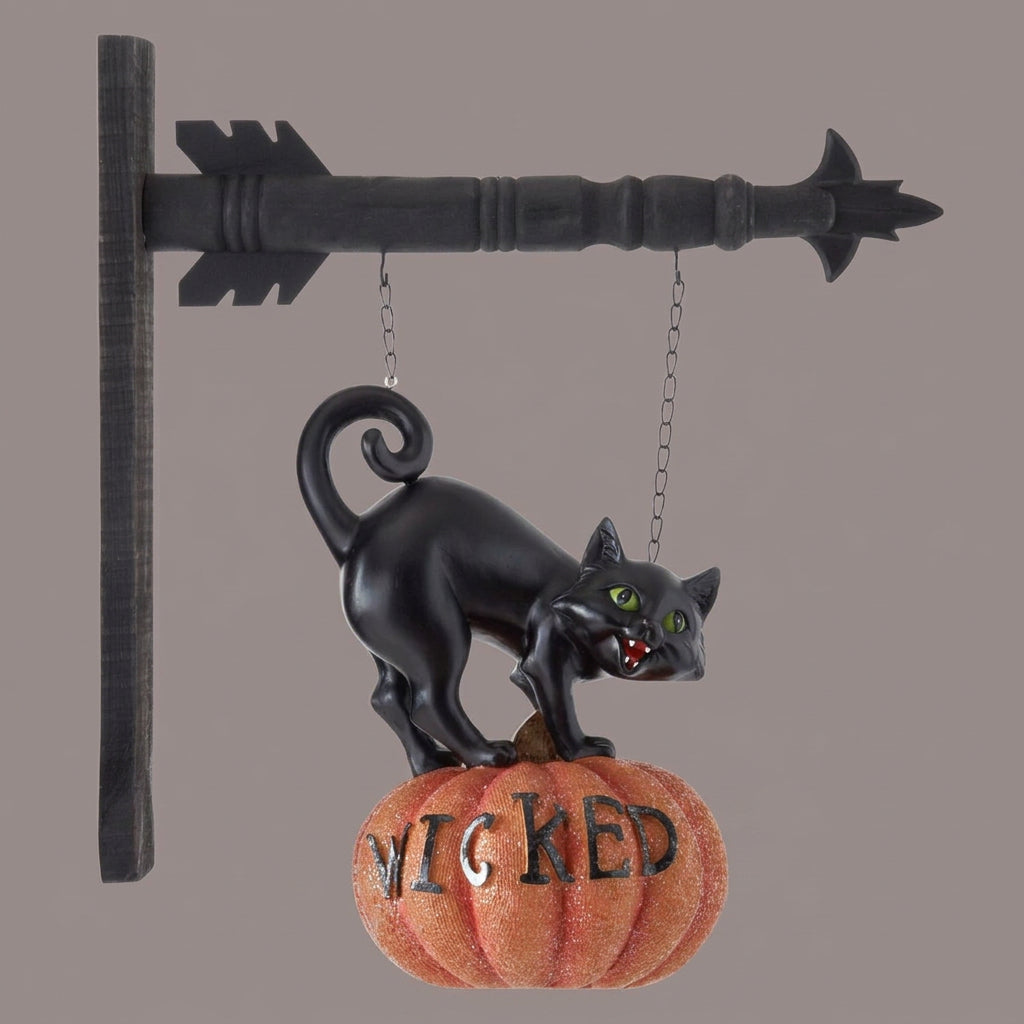 Decorative Halloween sign with a black cat on a pumpkin labeled 'Wicked'.