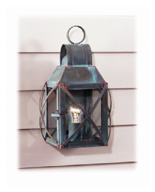 A wall-mounted Revere lantern with a Verdi Gris finish, made from copper, featuring a cylindrical shape with a decorative top and a lit window.