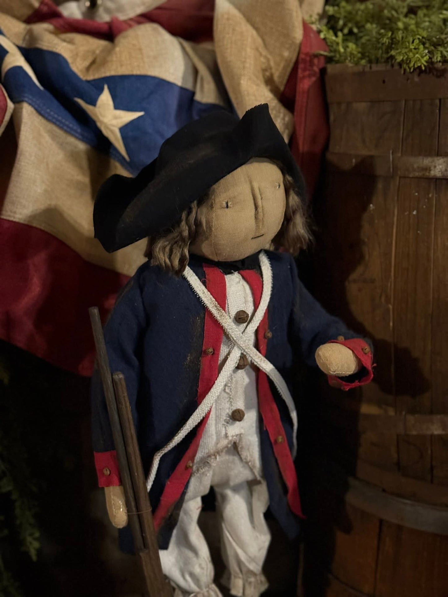 Doll in colonial attire with a flag in the background