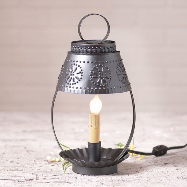 Punched tin lantern on rustic wood surface.