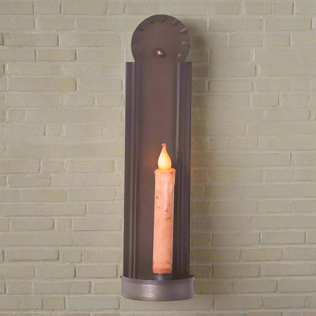 Slim colonial tin candle sconce holding a battery operated taper candle