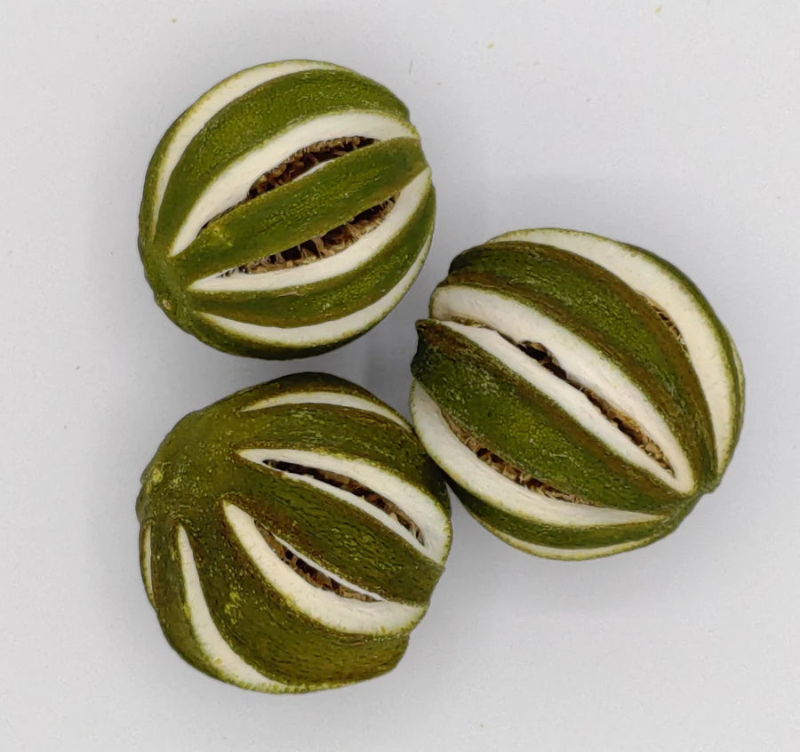 3 dried, slit limes on a white background