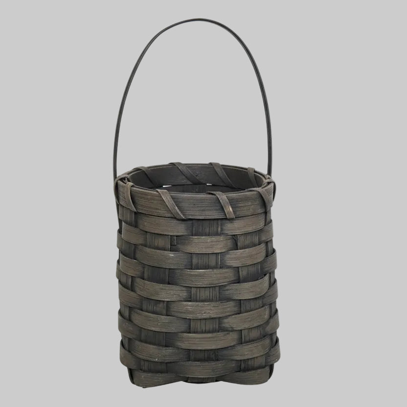 Woven basket with greenery on a wooden surface