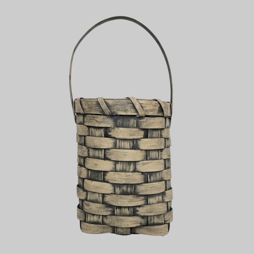 Woven basket with greenery on a wooden surface