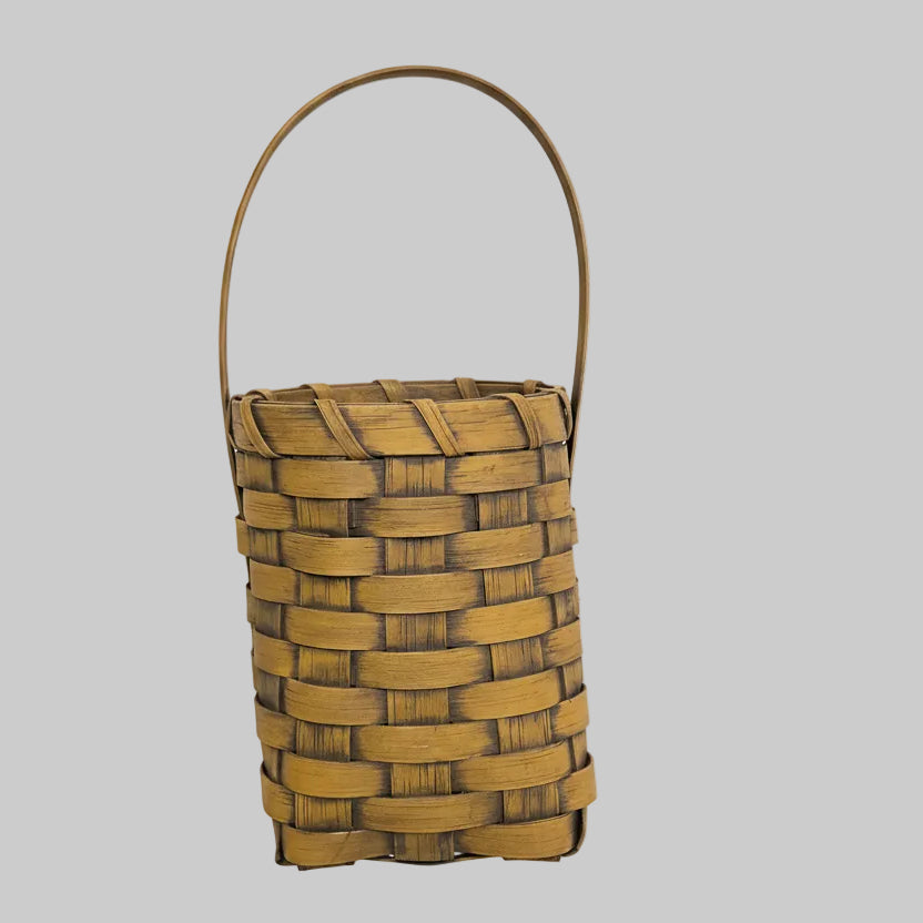 Woven basket with a plant on a wooden surface