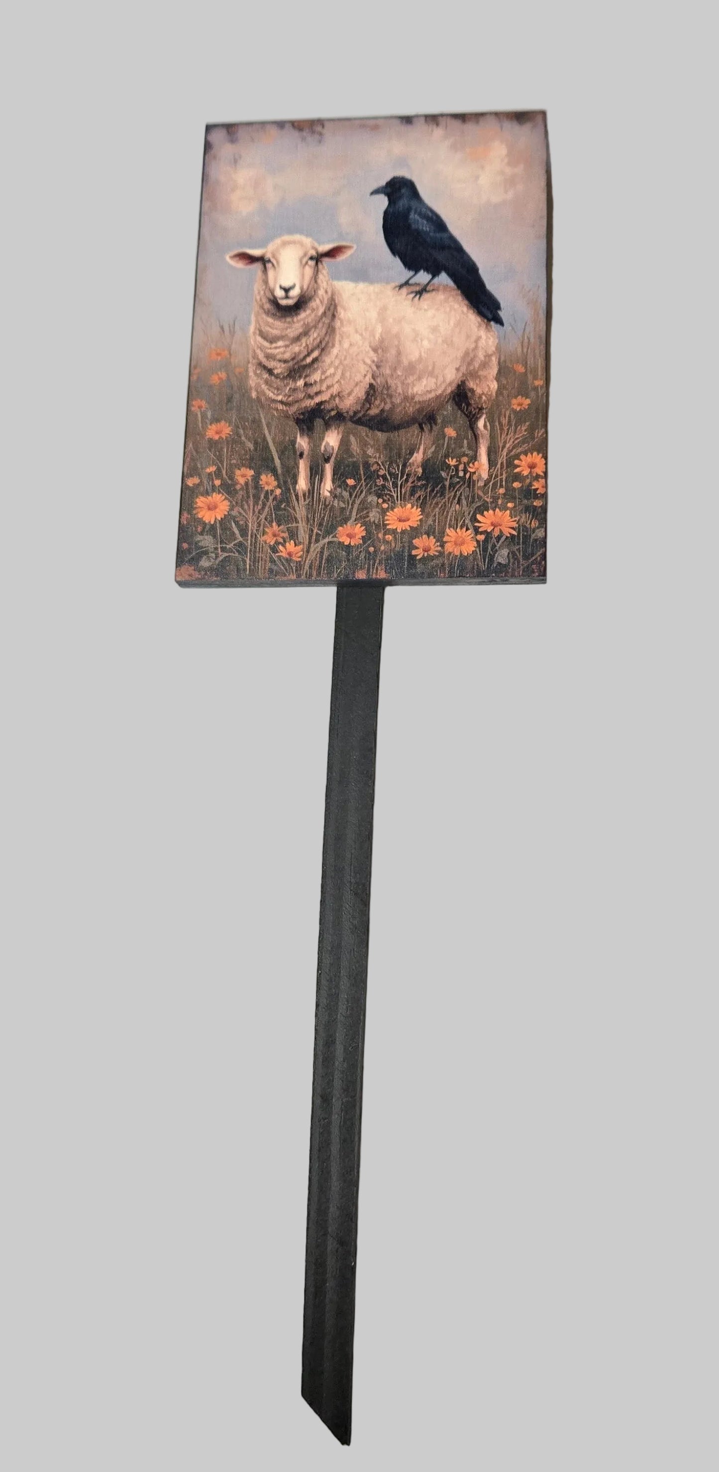 Decorative sign with a sheep and crow design on a gray background