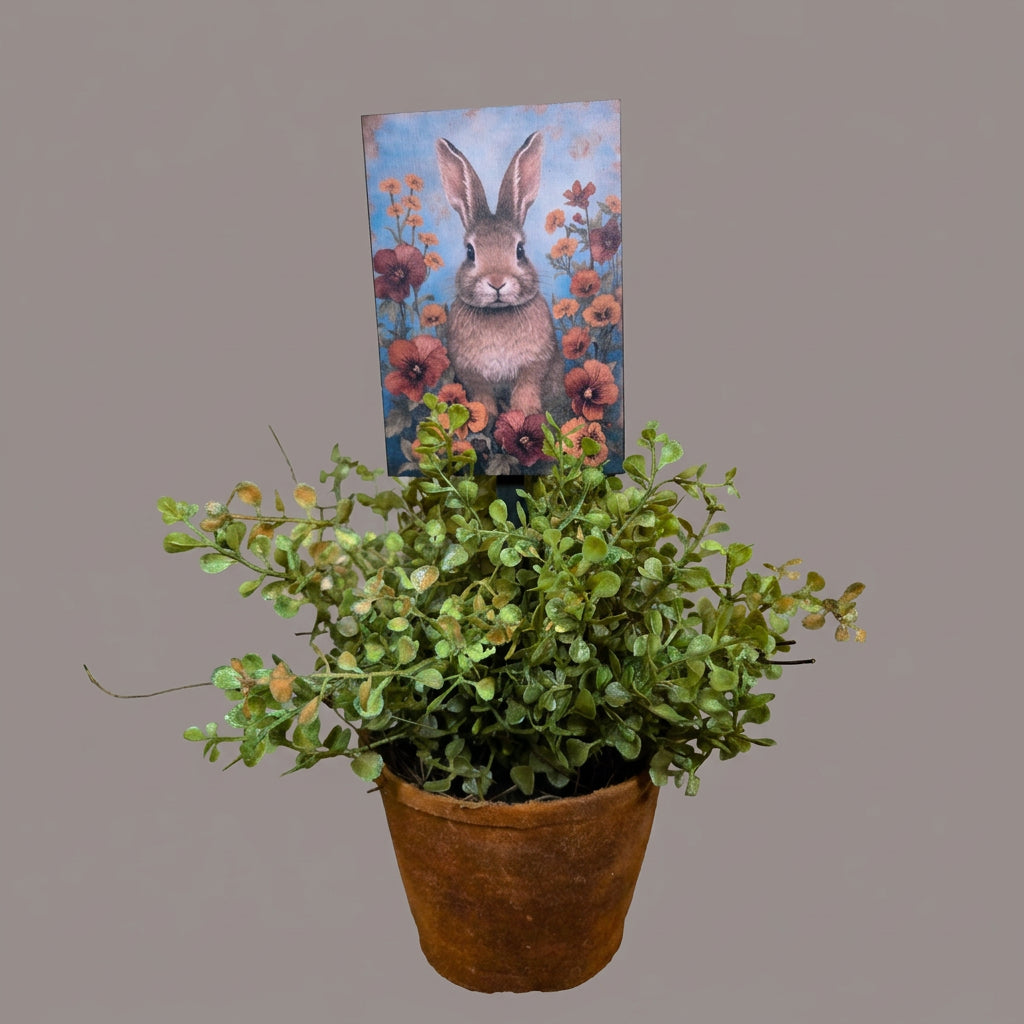Decorative painting of a rabbit with flowers on on a plant poke in a potted plant.
