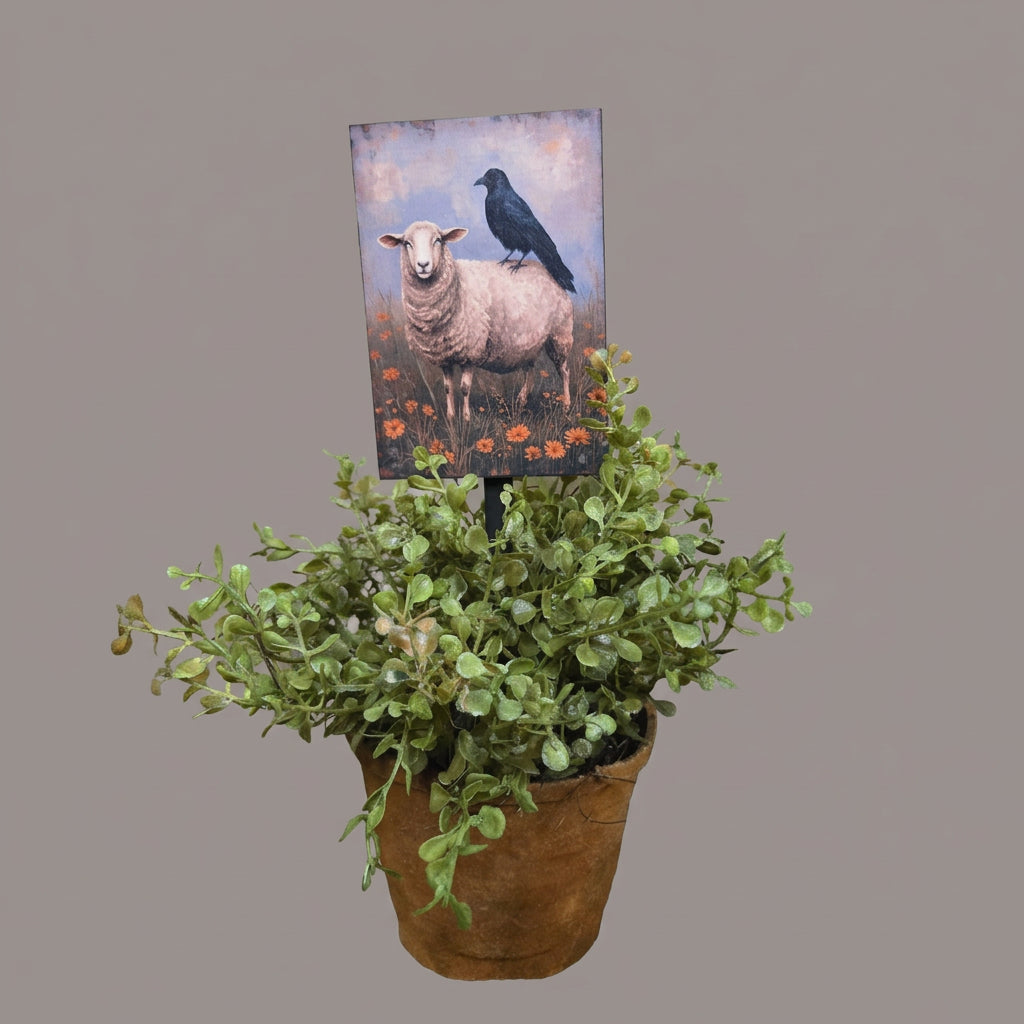 Potted plant with a picture of a sheep on a plant poke.
