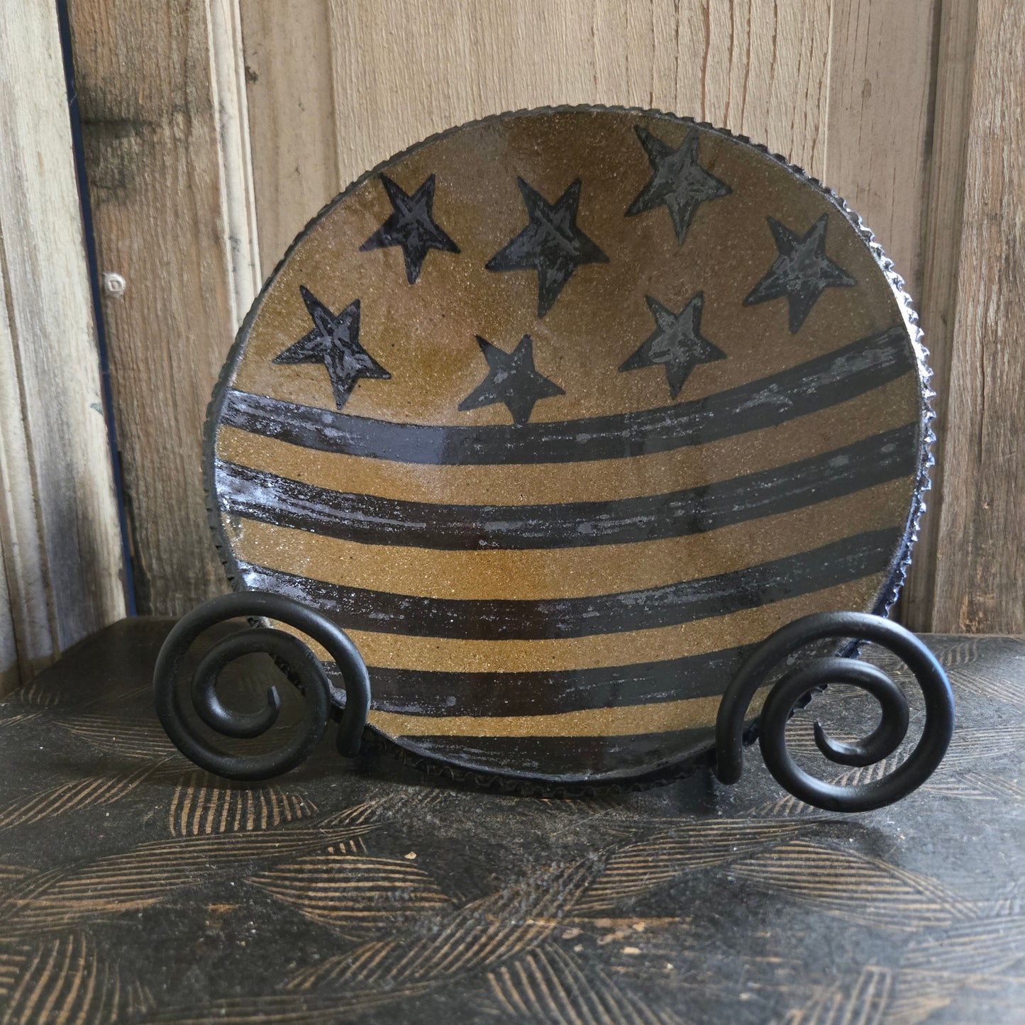 Decorative stoneware plate with stars ands stripes pattern on a wooden background