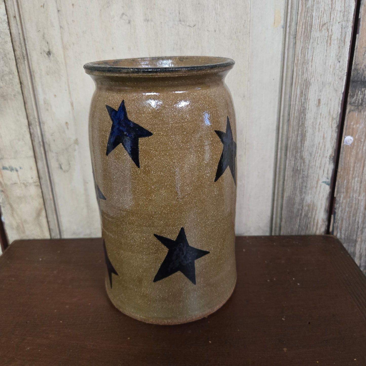 Ceramic vase with star patterns on a wooden surface