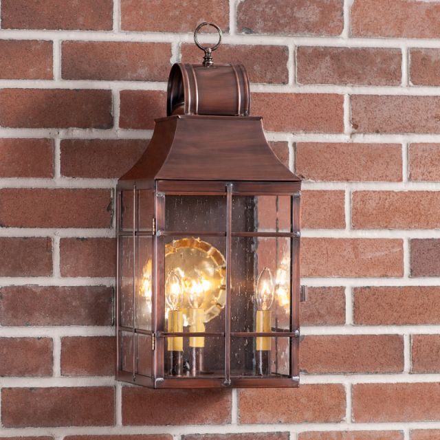 Copper lantern with glass panels on a brick wall