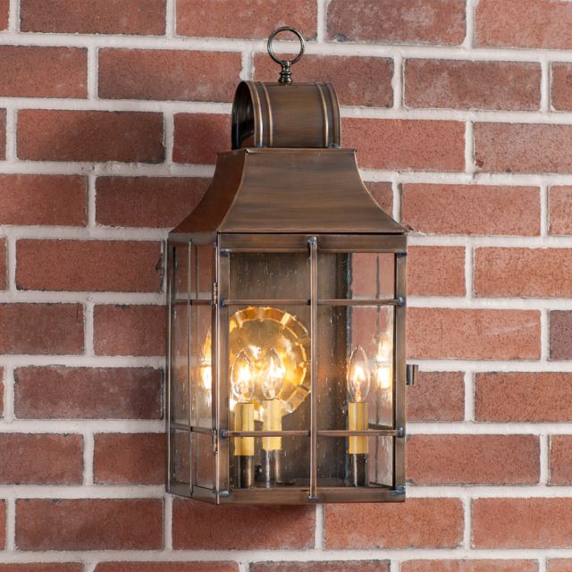 Decorative outdoor wall light fixture on a brick wall