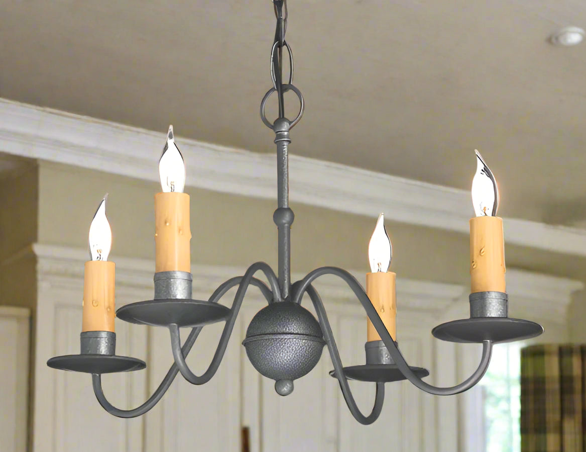 A wrought iron chandelier with a pewter color finish, featuring a classic design with four lights and wooden shades.
