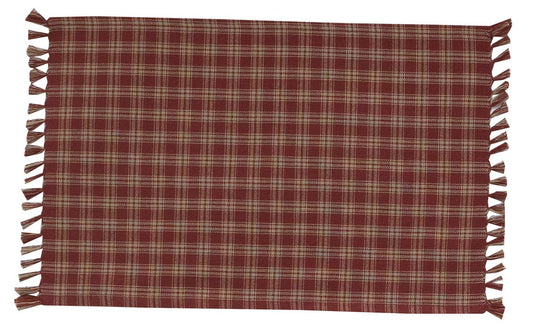 A red and tan checkered Sturbridge placemat with fringes on the edges placed on a table.
