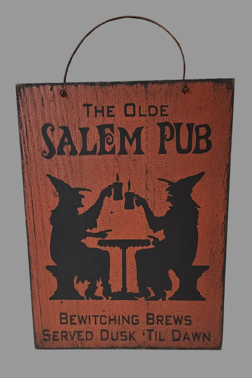 Wooden sign with 'The Olde Salem Pub' design featuring silhouettes of witches and text.