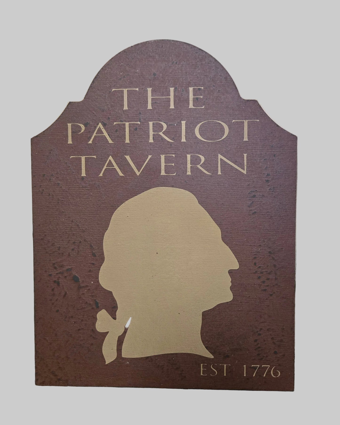 Sign for 'The Patriot Tavern' with a silhouette of a man's head on a wooden background