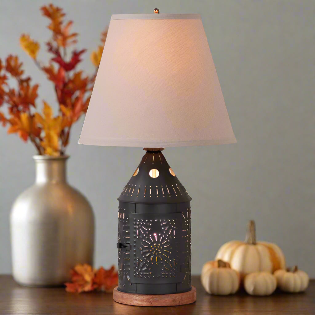 Decorative table lamp with a textured black base and beige lampshade on a white background