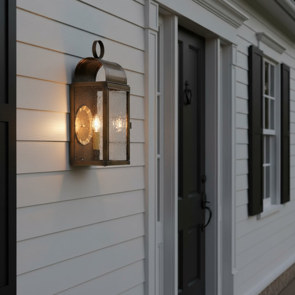 Colonial outdoor brass wall light with bubbly glass on a colonial home.