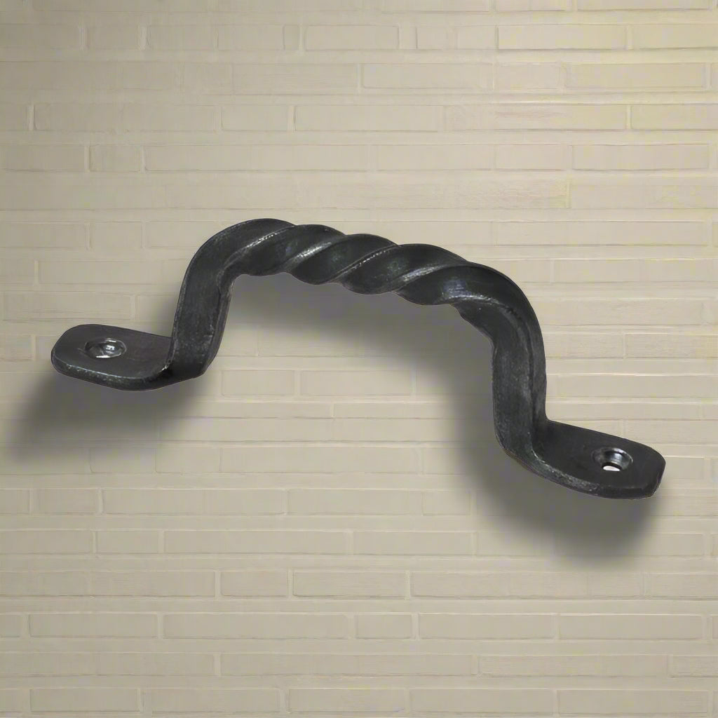 A twisted wrought iron cabinet pull handle with an antique finish, featuring a decorative twist on the handle, mounted on a flat surface.