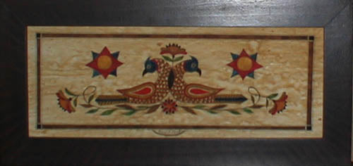 A piece of art with a floral and bird design, featuring entwined lovebird motifs in a rectangular frame.