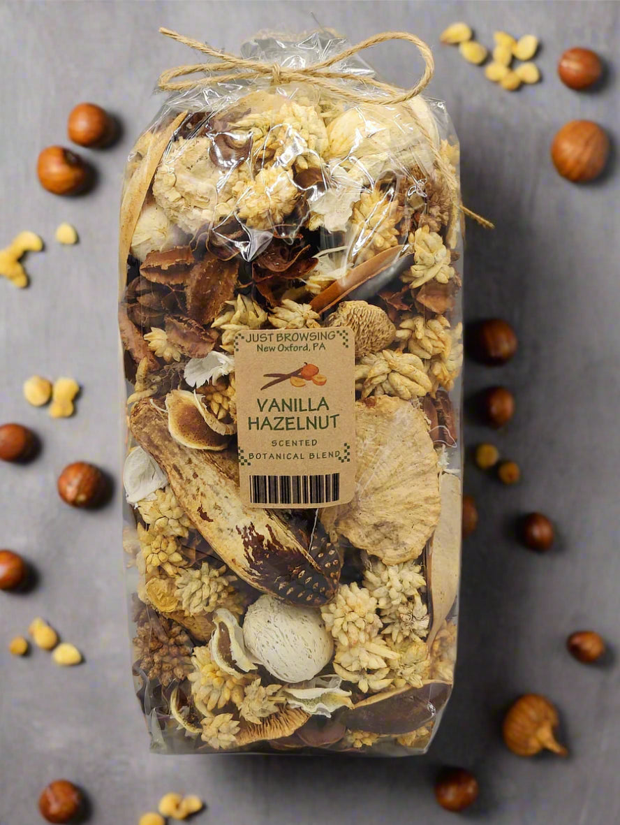 A clear plastic bag containing a vanilla hazelnut potpourri blend, tied at the top with a ribbon and labeled with a tag.