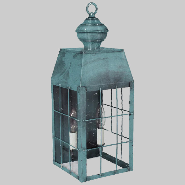 Teal metal lantern with glass panels on a white background
