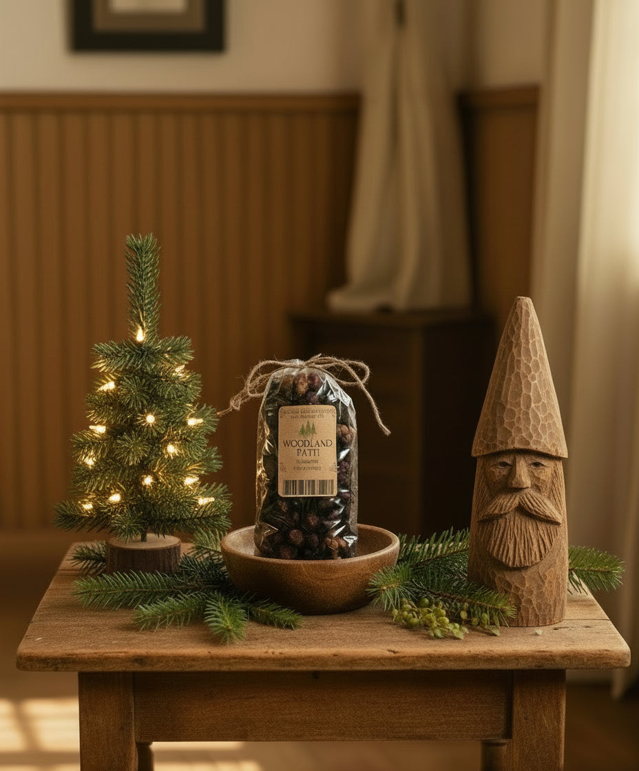 Decorative setup with a small Christmas tree, wooden gnome, and pinecones on a wooden table.