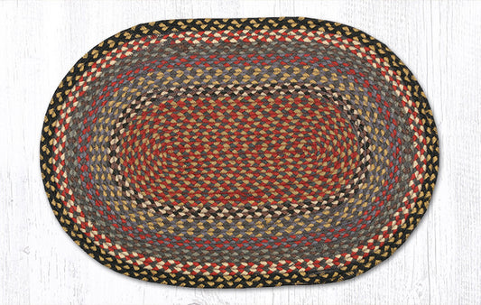 An oval braided jute rug with concentric bands of red, brown, gray, and beige, shown flat against a white wood-plank background.