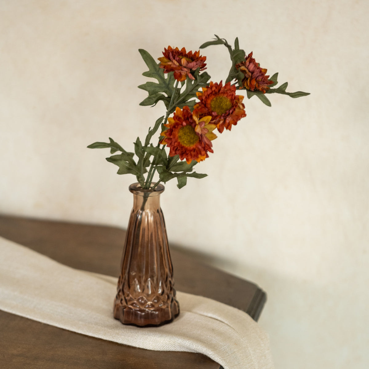 Decorative vase with artificial flowers on a textured surface