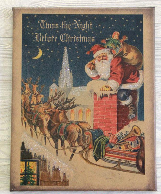 A canvas print with the title 'Twas the Night Before Christmas featuring an illustration of Santa Claus on a chimney with reindeer and a cityscape in the background.